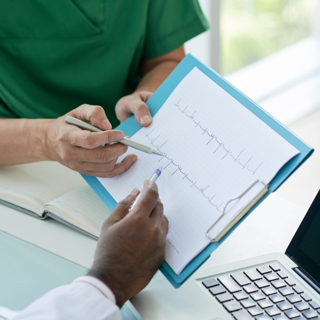 Arzt der ein EKG mit seinem Patienten durchgeht.